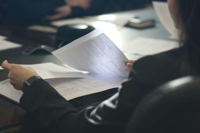 Person sitting at a table reading a document