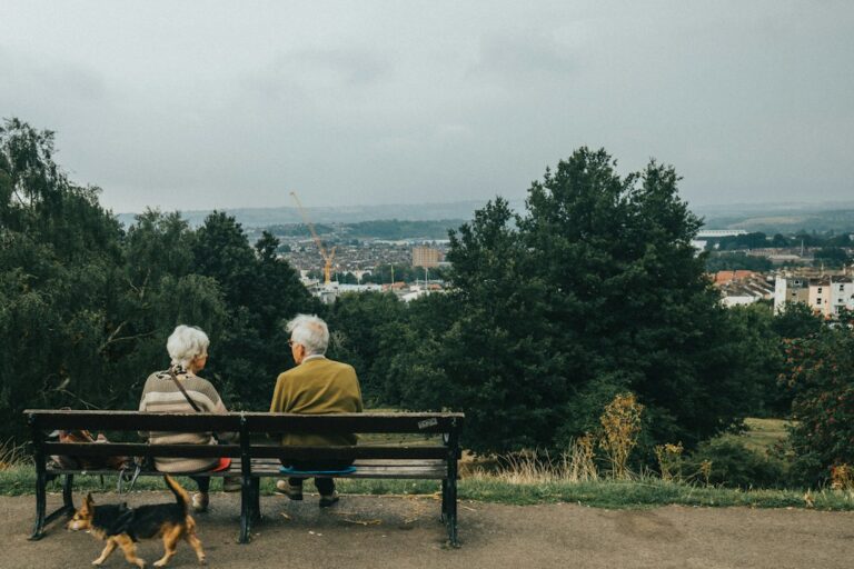 Older couple sitting on a bench with a dog, representing retirement planning and future State Pension changes