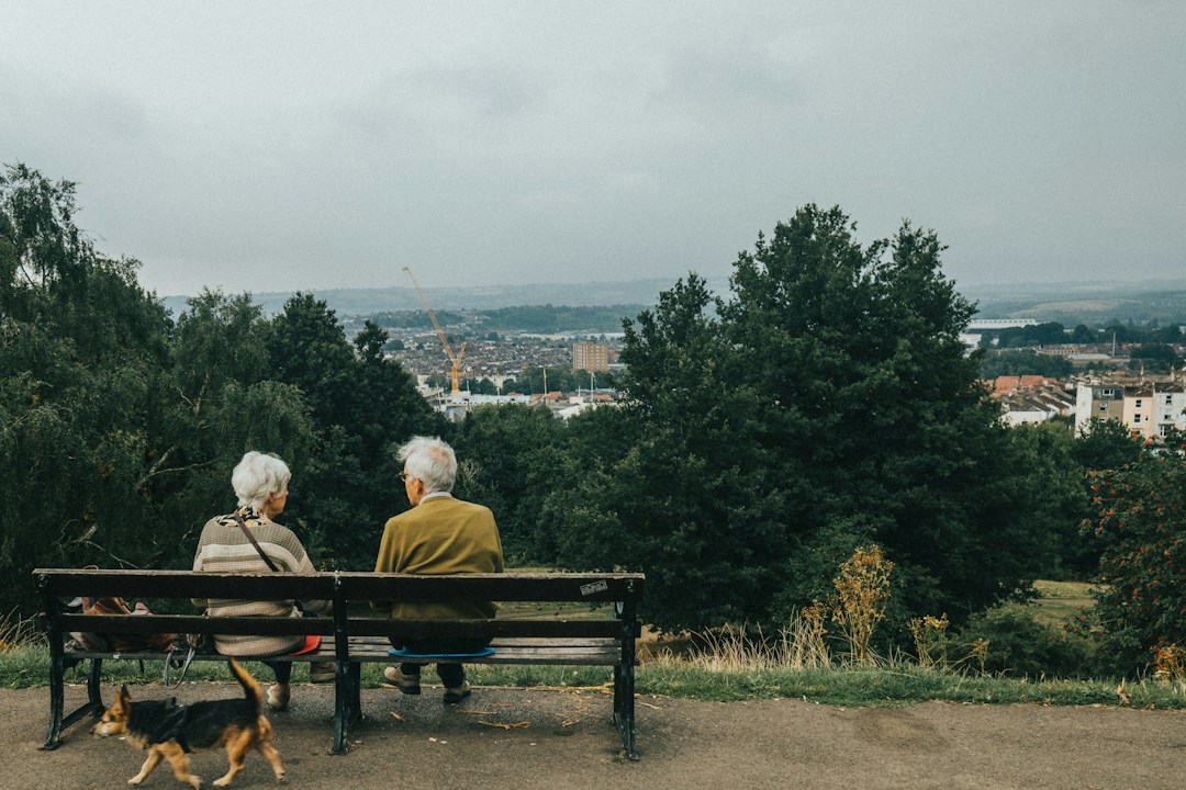 Older couple sitting on a bench with a dog, representing retirement planning and future State Pension changes