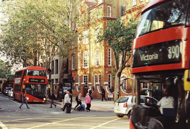 A red London double-decker bus travelling along a London street