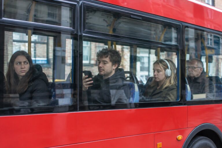 Bus Passenger Using Headphones While Travelling on a Bus in England